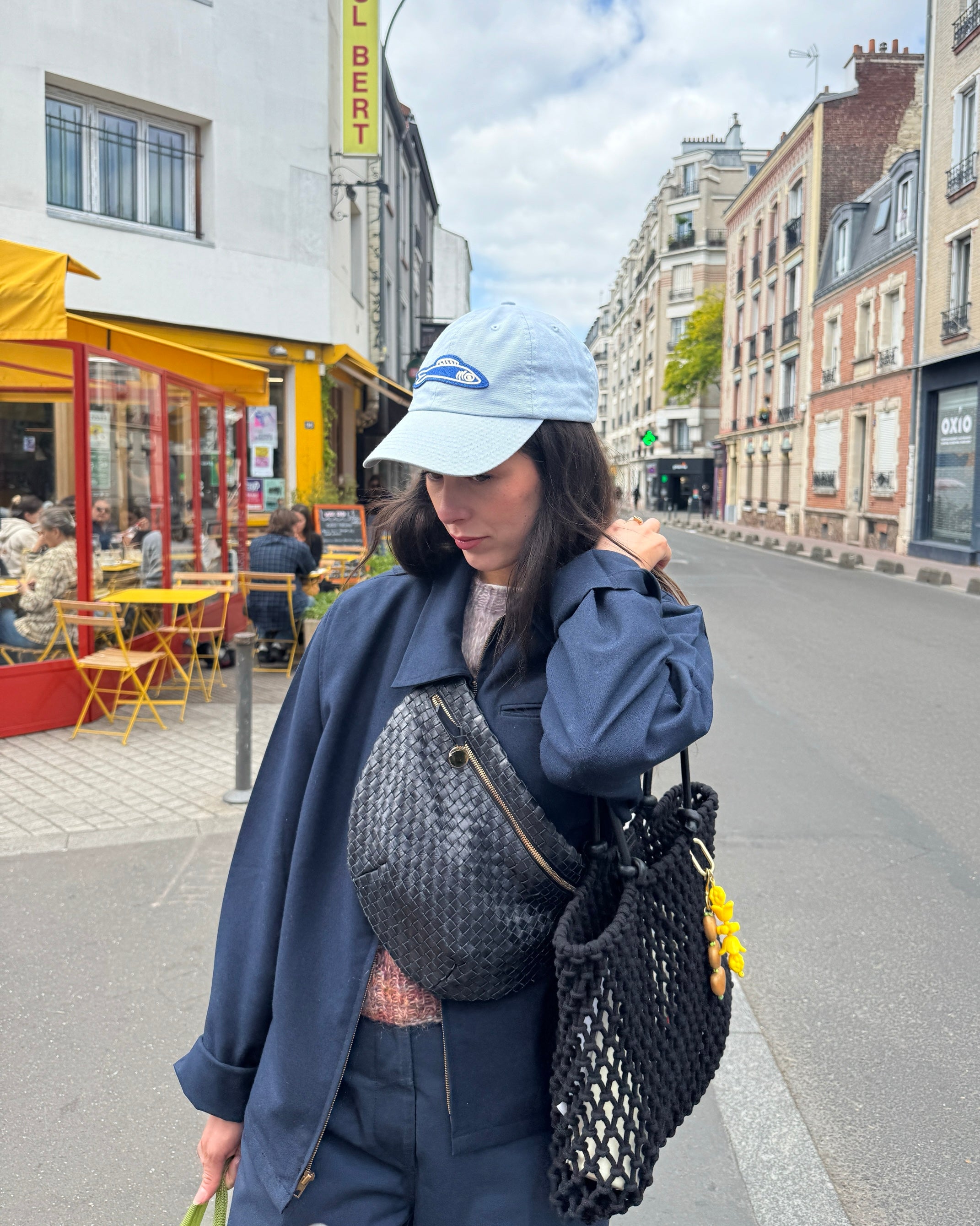 Woman carrying the Black Sandy over her shoulder and Black Woven Grande Fanny across her chest.