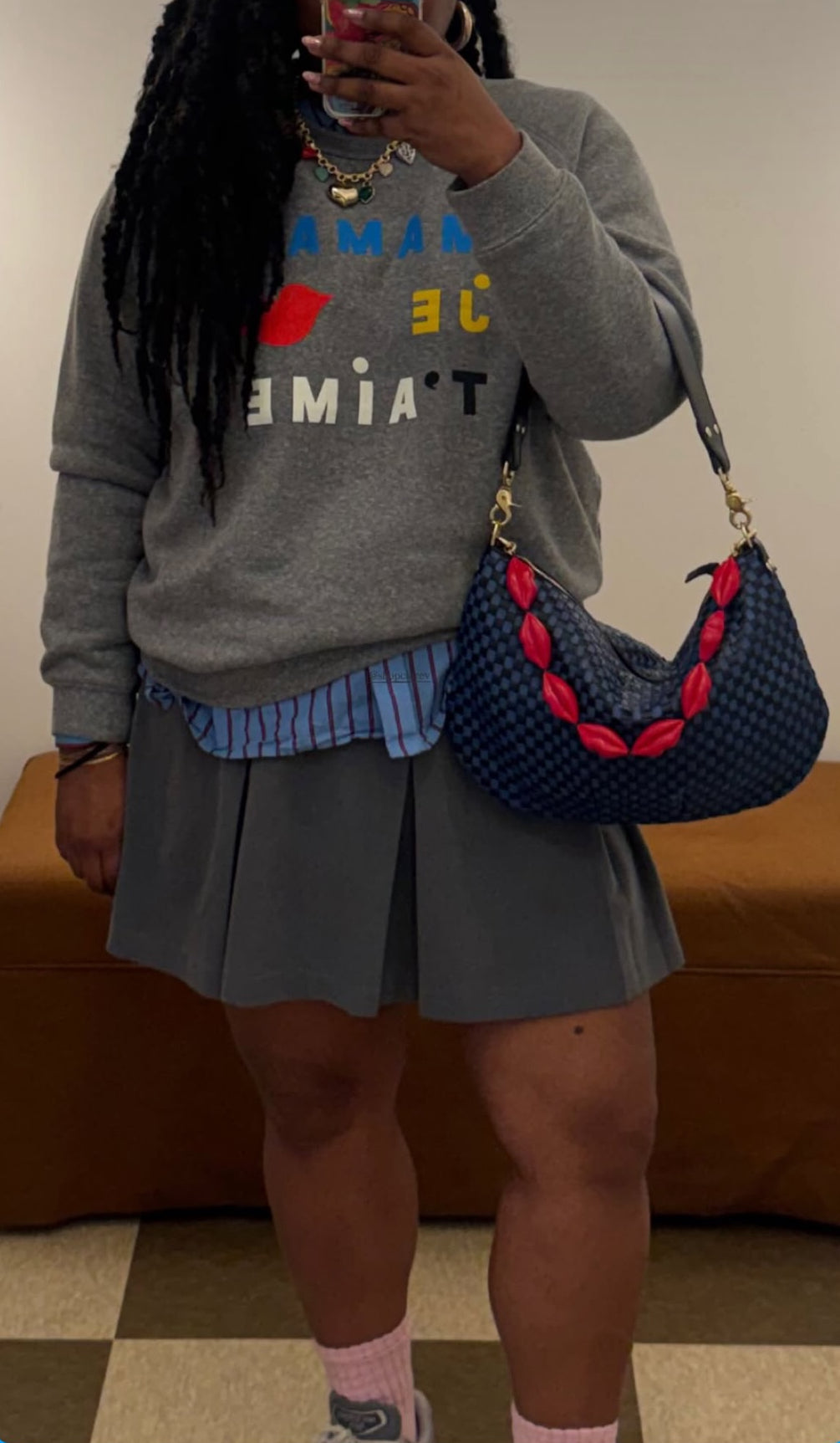 Woman taking a mirror selfie with her Black and Cobalt Woven Checker Moyen Messenger with Lips Shortie Strap attached to it. 