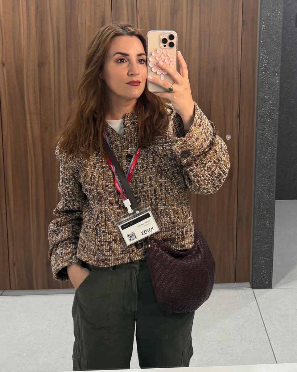 Woman taking a selfie and carrying the Moyen Messenger as a crossbody bag. 