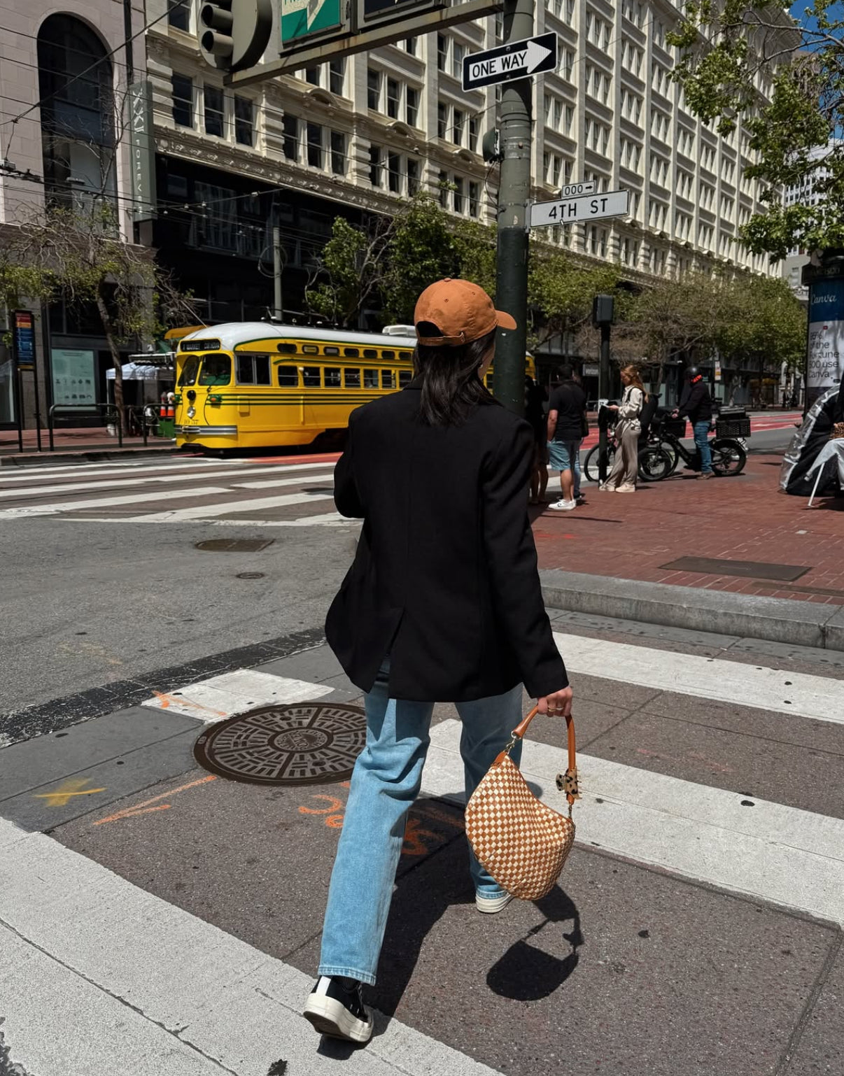 Woman carrying the Natural and Cream Checker Petit Moyen as she's crossing the street. 