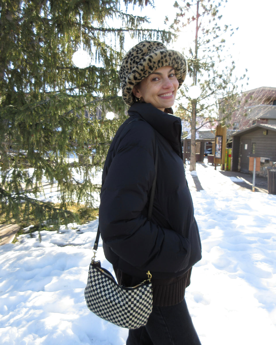 Woman carrying the Black and Cream Checker Petit Moyen while out in the snow. 