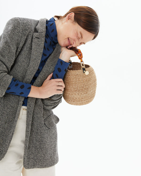 Zoe with her arms crossed in a blazer with the Pot de Miel w/ Resin Top Handle in her left hand