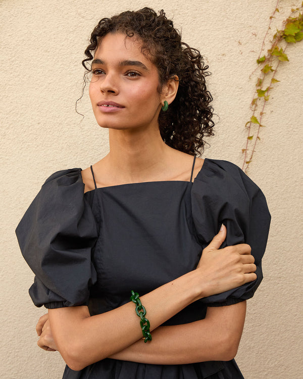 Haro wearing the emerald le hoop earrings with her hair back in a pony tail