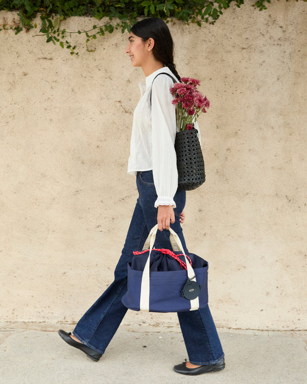 Model walking and carrying the Clare V. x Staub Le Dutch Tote. 