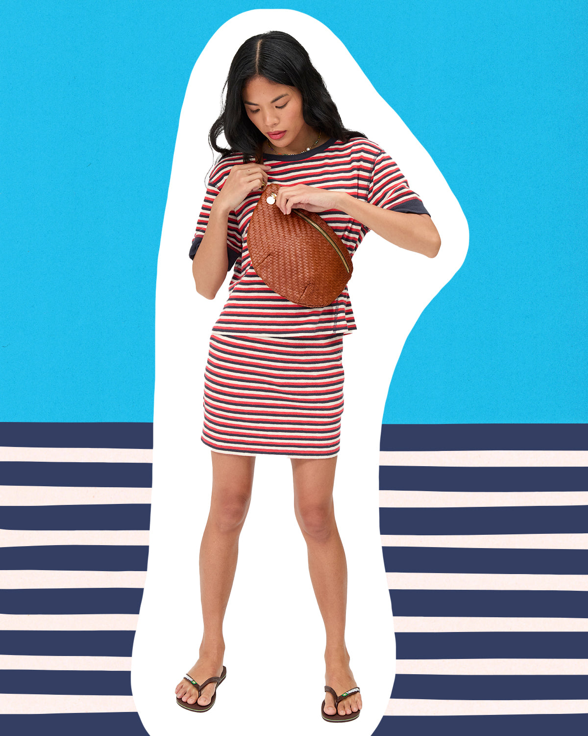 Model carrying the Hazelnut Grande Fanny and wearing the Navy, Cherry, and Cream Stripe Le Bateau Tee and Le Mini Tube Skirt.