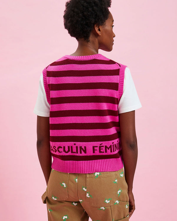 back view of the model wearing the Neon Pink & Oxblood Stripes sweater vest over a white tee shirt 