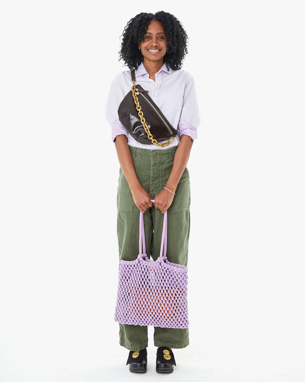 mecca holding the Lilac Sandy in front of her green pants