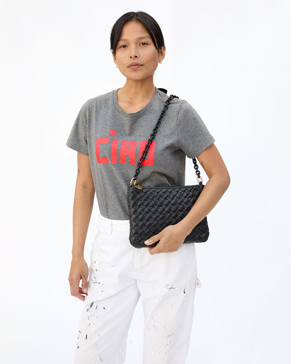Maly carrying a flat clutch on her shoulder with the Black Mini Resin Shoulder Strap