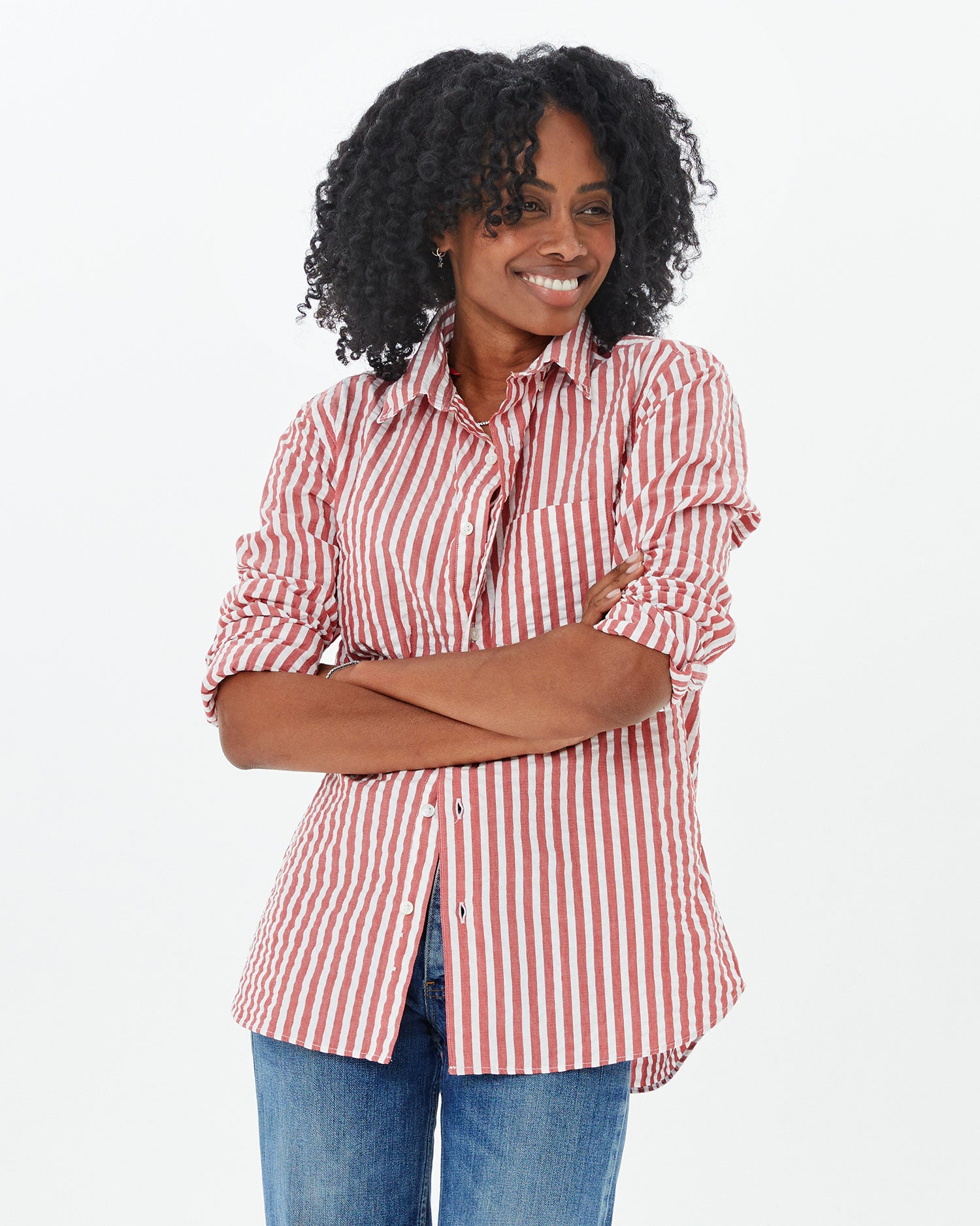 mecca in the  Poppy & cream Stripe Single Needle Shirt and jeans with her arms folded across her chest