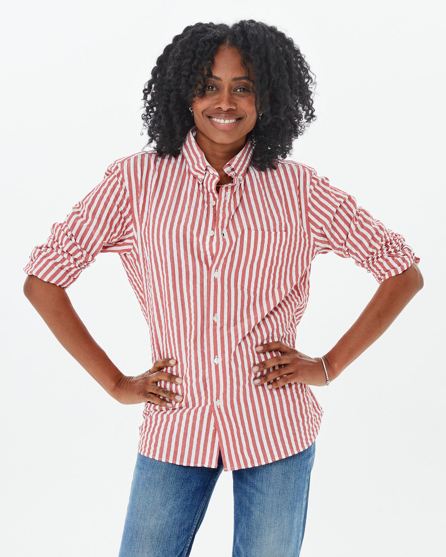 Mecca wearing the Poppy & cream Stripe Single Needle Shirt with jeans. her hands are on her hips