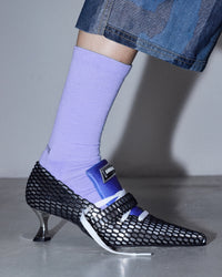 model wearing the SOCKSSS Original Socks in It's Not Blue with heels and jeans