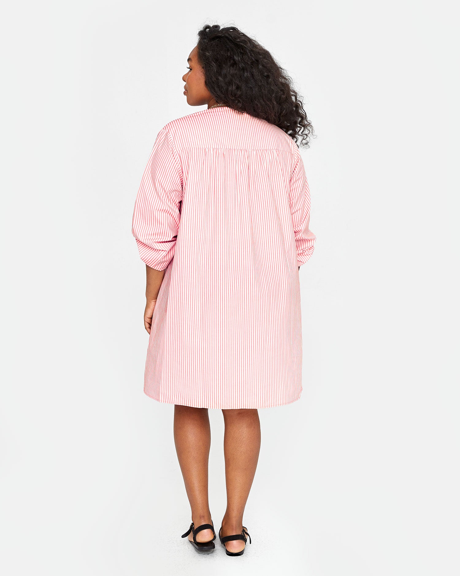 back view of candice in the Flamingo & Cream Stripe St Martin Dress
