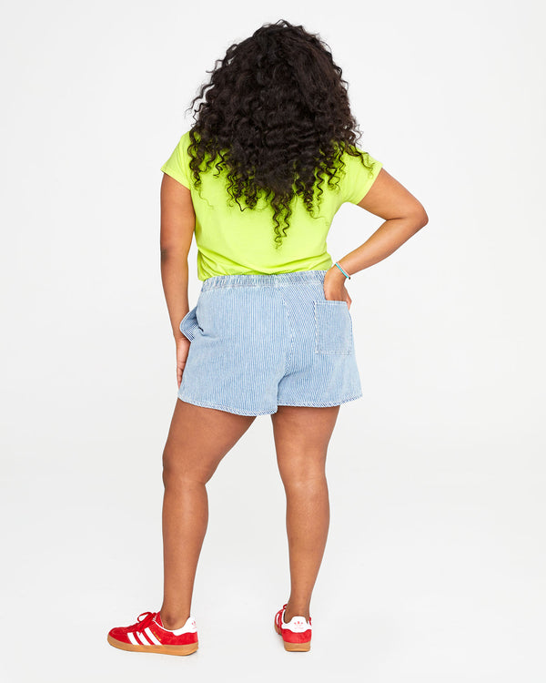 back view of candice wearing the engineer stripe st martin shorts  and the neon yellow ciao tee