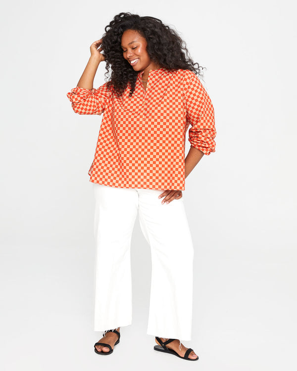 candice wearing the Poppy & Khaki Checker St. Martin Top with white pants