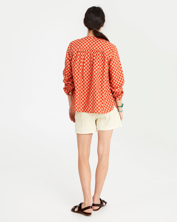 danica facing away from the camera in the Poppy & Khaki Checker St. Martin Top and khaki shorts
