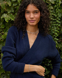 Haro wearing the Sterling Silver Star Strand Bracelet and the sapphire tennis necklace with a navy blue cardigan