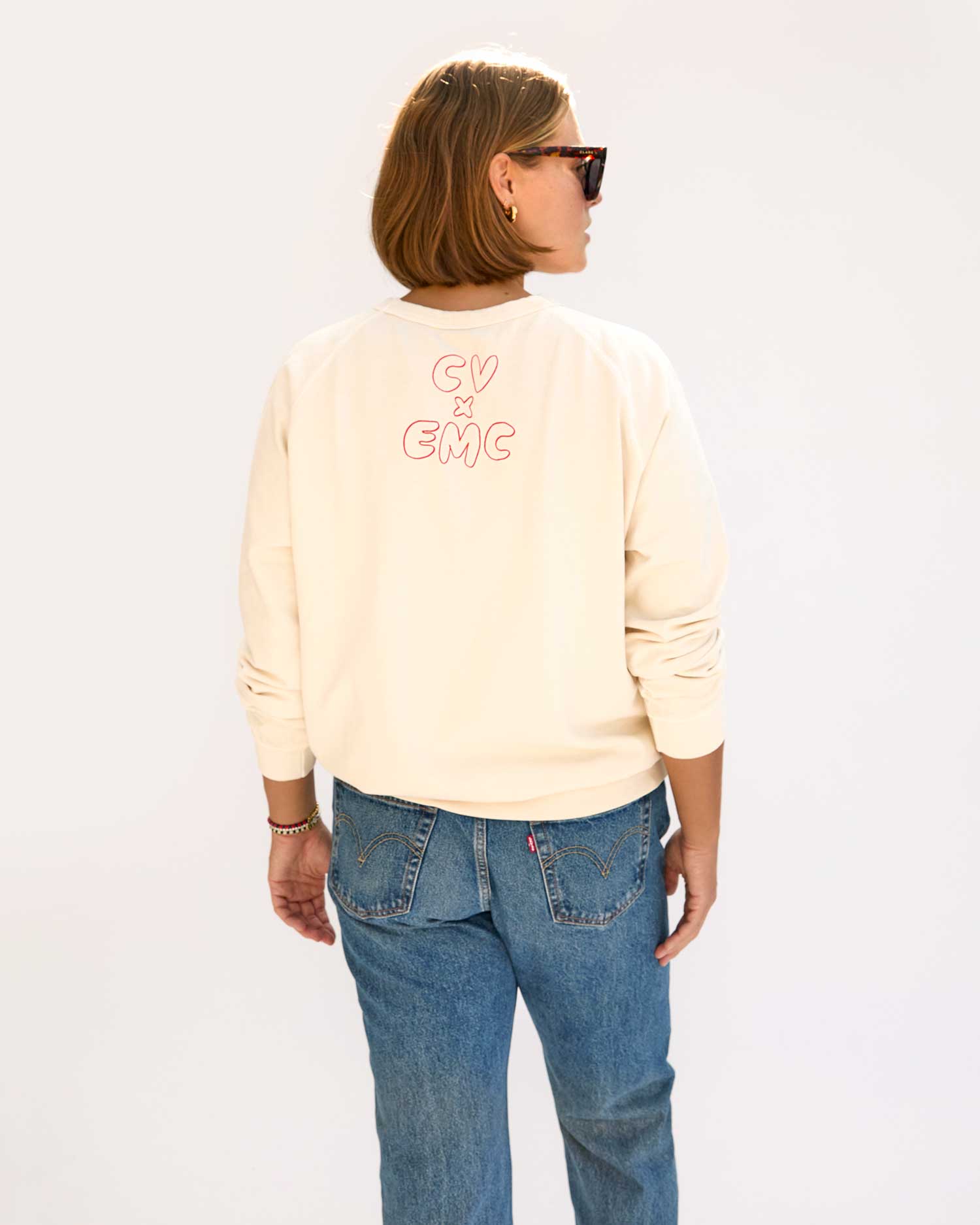 back view of Sonnie wearing the Cream w/ Liberté Ègalité Maternité Sweatshirt with jeans