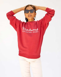 Maly wearing the Brentwood Red w/ Cream BCM Sweatshirt with white pants
