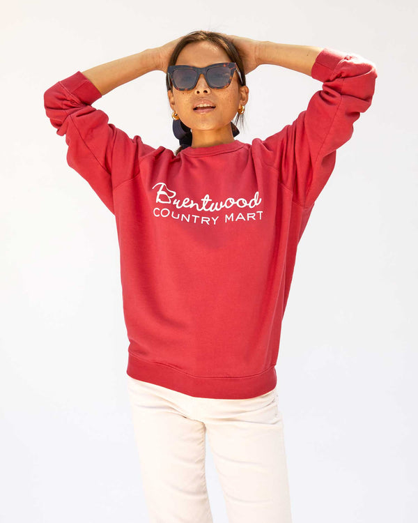 Maly wearing the Brentwood Red w/ Cream BCM Sweatshirt with white pants