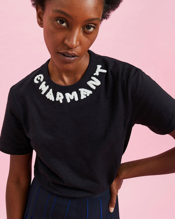 Model wearing the Black w/ Cream Charmant Tee  with the Pleated Skirt