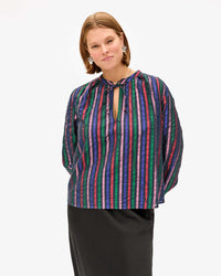 Sonnie wearing the Multi Stripe Thea Blouse with a black skirt