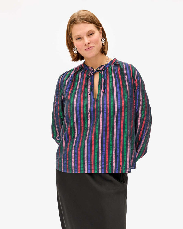 Sonnie wearing the Multi Stripe Thea Blouse with a black skirt