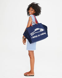Mecca carrying the Navy Liberez Les Sardines Trucker Beach Tote over her shoulder. Mecca is also wearing our Cobalt & Cream Petit Stripe Raglan Tank Dress. 