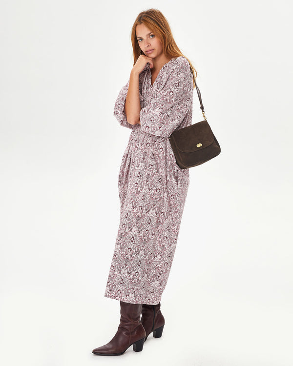 Aurelia wearing a long floral dress with brown boots and the Chocolate Suede Turnlock Louis on her shoulder
