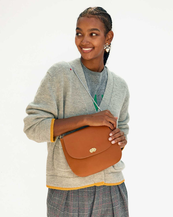 Jordan carrying the Cuoio Turnlock Louis by the silver snake chain shoulder strap
