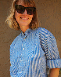 Lou smiling and wearing the Steven Alan Tux Shirt In Blue and Cream Stripe with the sleeves rolled up