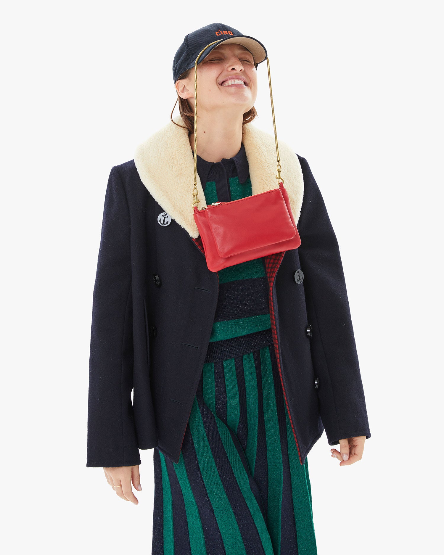 Rouge Wallet Clutch Plus with the Vintage Gold Snake Chain Shoulder Strap hanging off the brim of her hat