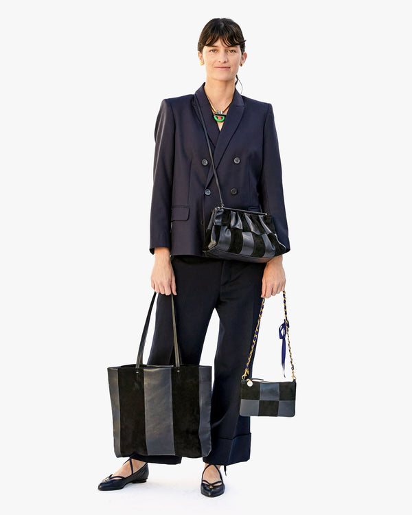 Danica wearing the belle crossbody, the bande tote in her right hand and the Royal Blue Grosgrain Chain Shoulder Strap on the wallet clutch with tabs in her left hand