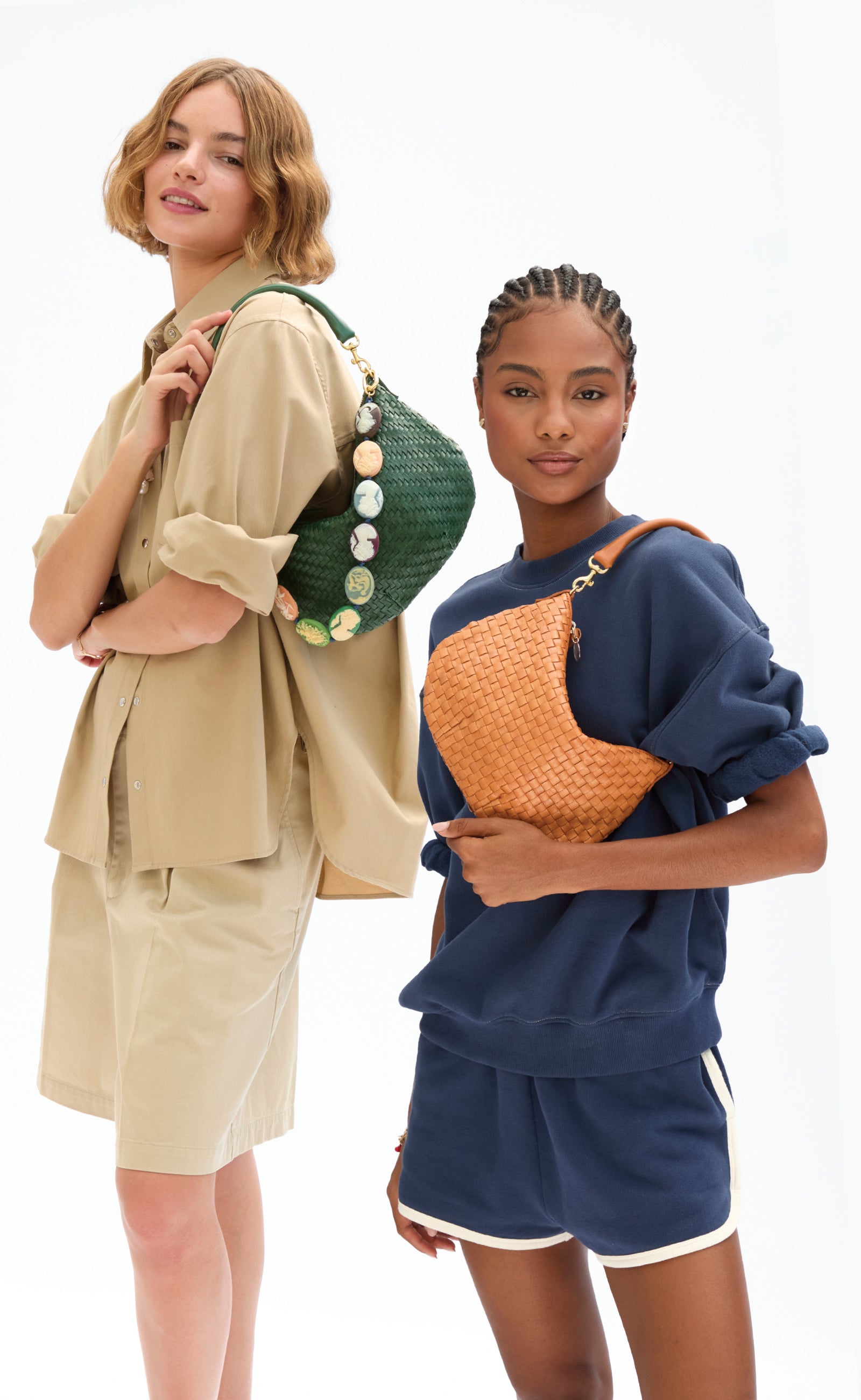 Two models carrying the Petit Moyen as a shoulder bag. One is carrying the Evergreen Woven Petit Moyen with Multi Cameo Shortie Strap. The other model is wearing the Navy Oversized Short Sleeve Sweatshirt with matching Le Jogging Shorts and carrying the Natural Woven Checker Petit Moyen. 