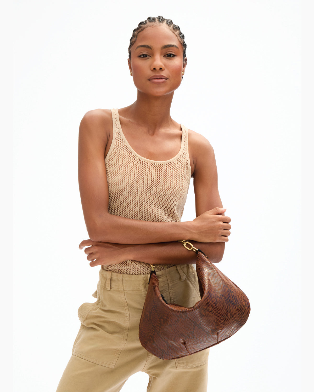 Model carrying the Auburn Embossed Python Moyen Messenger with Top Handle Bébé in Gold Sardine attached to the Moyen. 