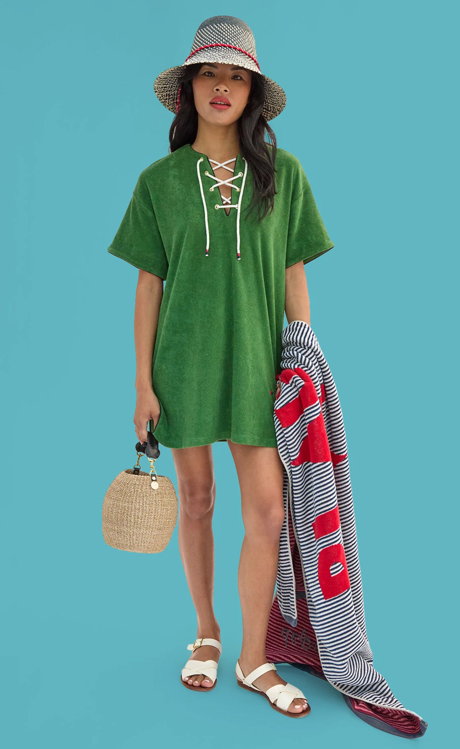 Model wearing La Plage Dress and Romy Hat while carrying Le Towel and Cream Pot de Miel.