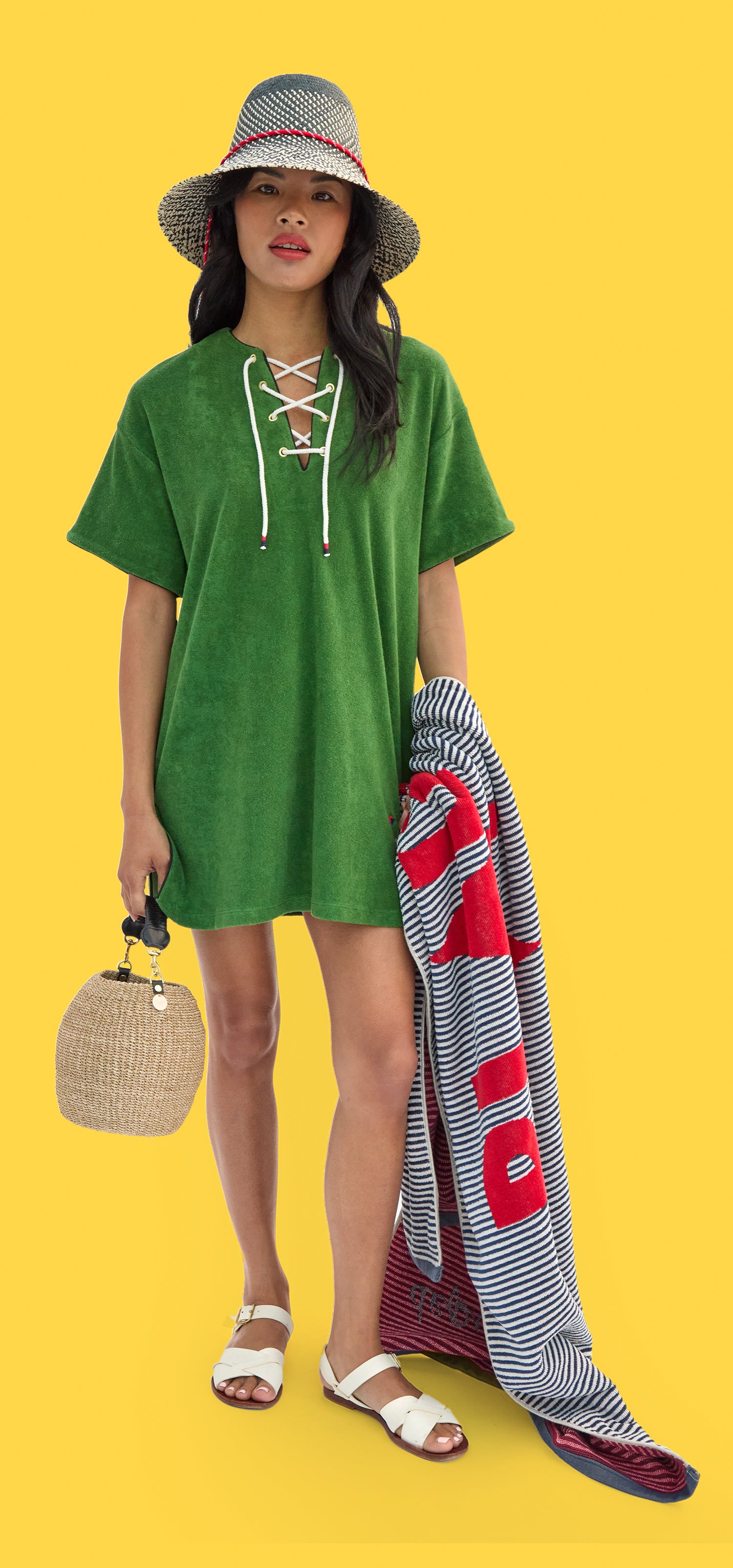 Model wearing La Plage Dress and Romy Hat while carrying Le Towel and Cream Pot de Miel.