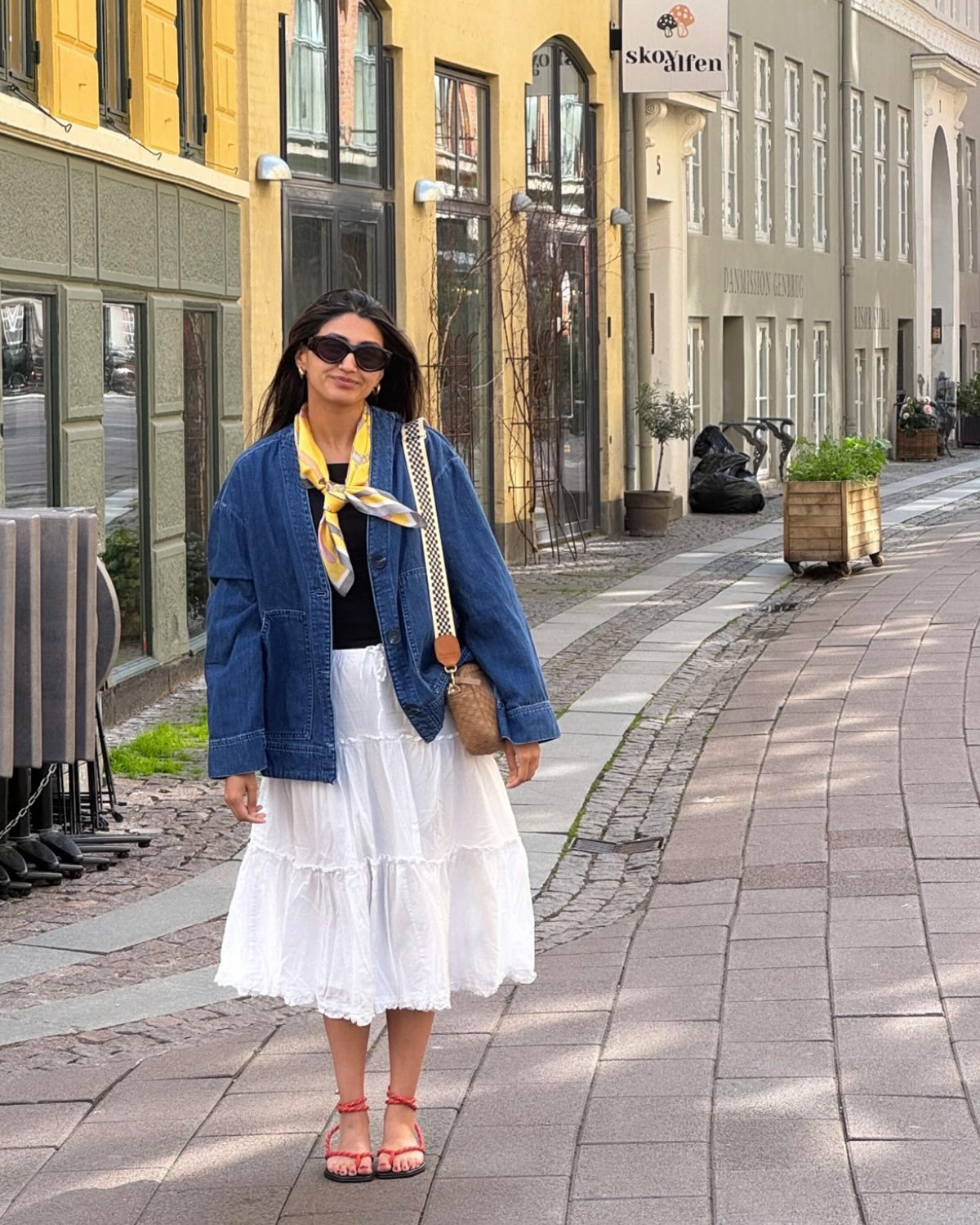 Woman carrying the Sequoia Midi Sac with Black and Cream Checkered Adjustable Strap. 