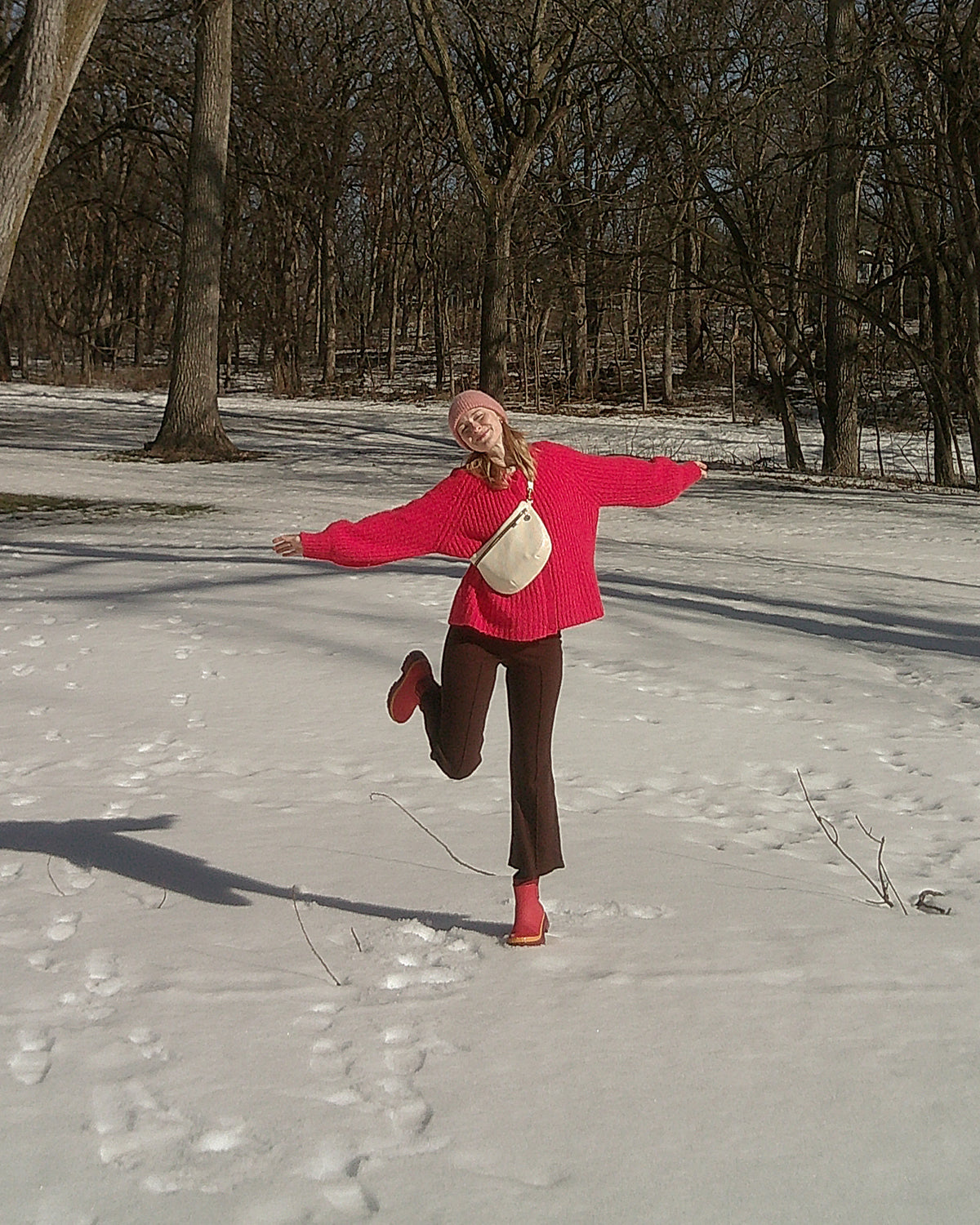 Woman standing in the snow and wearing a white Grande Fanny across her chest.