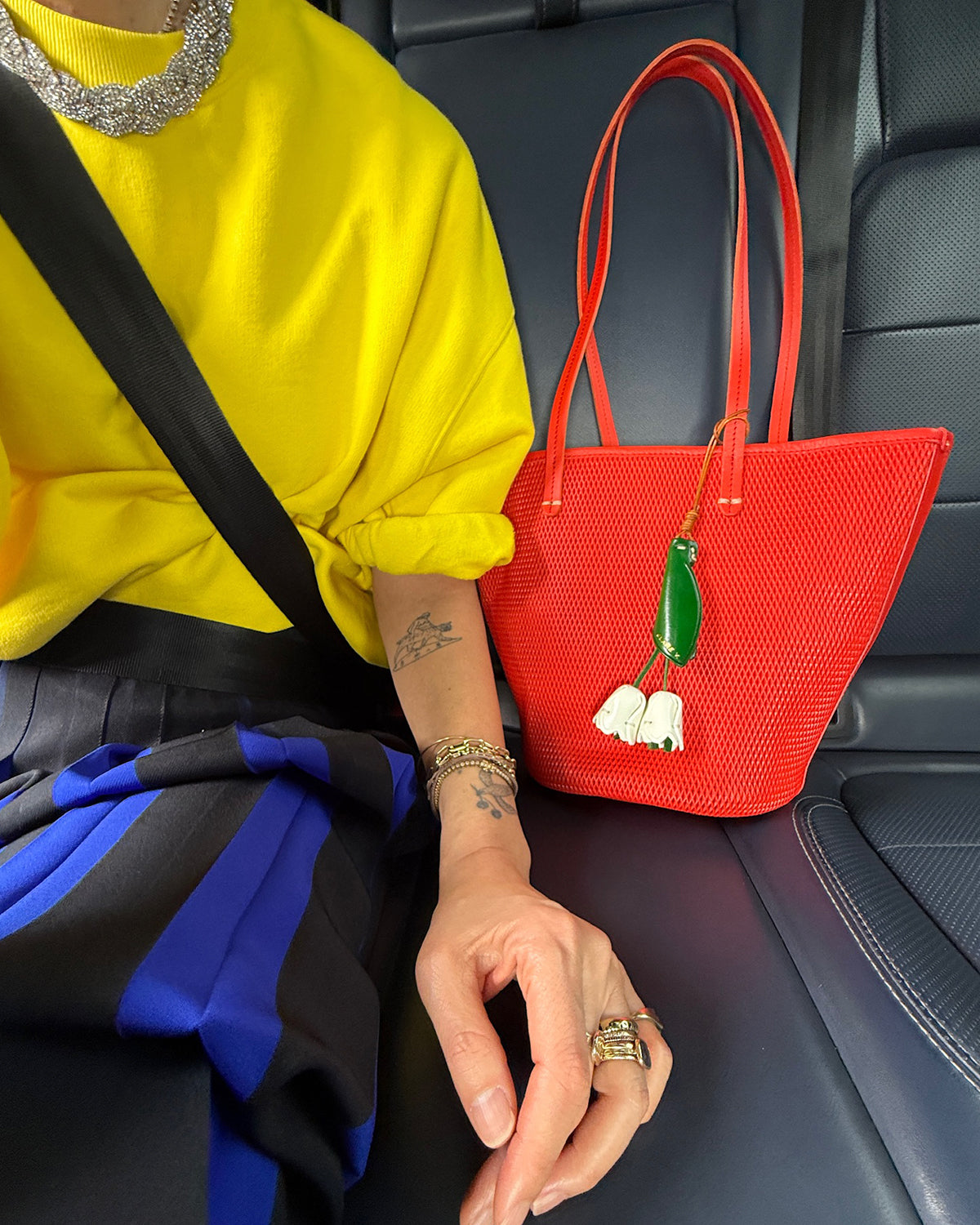 Woman in a car with her Bright Poppy Choupette next to her. 