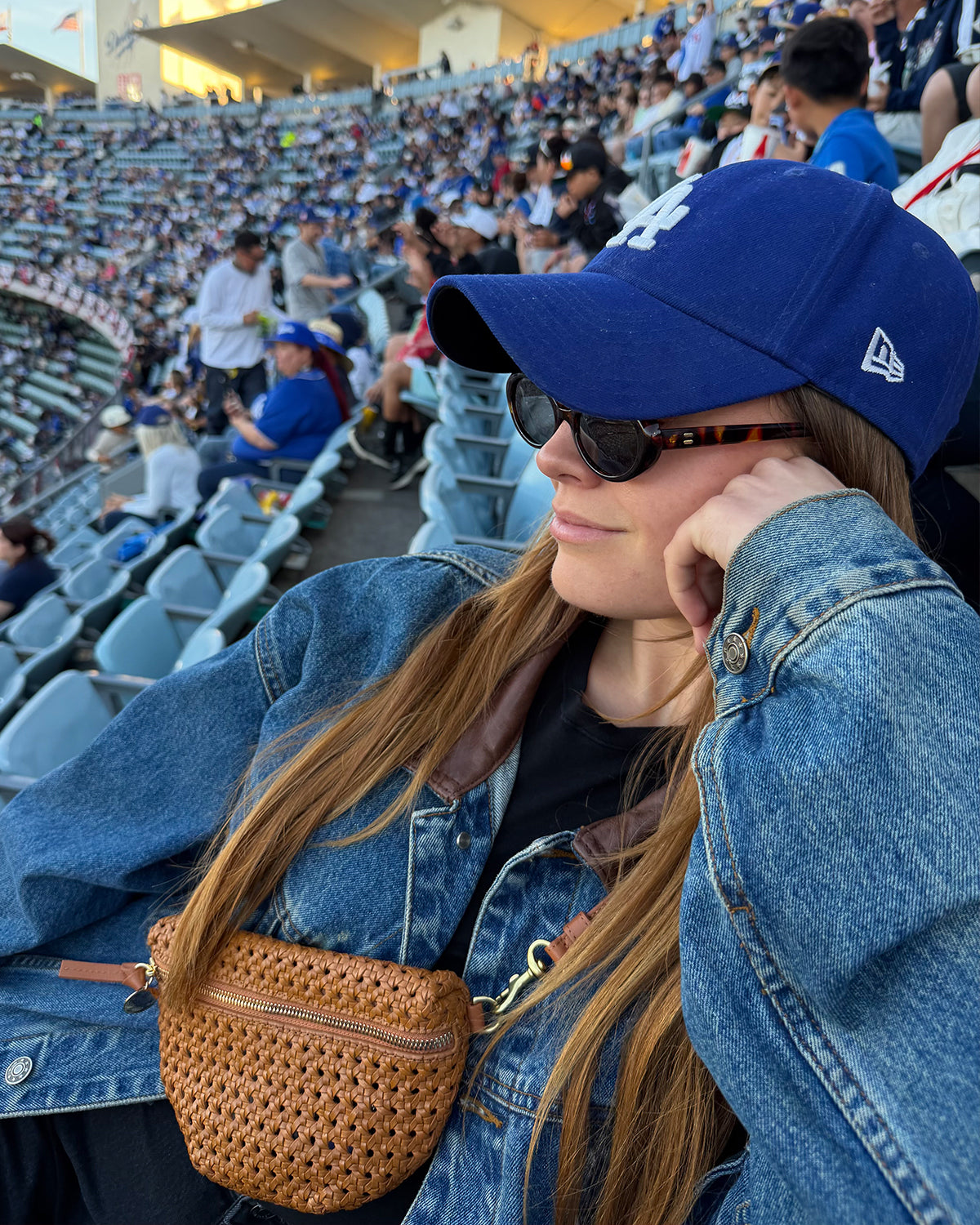 Woman at the L.A. Dodgers game wearing the Tan Rattan Petite Fanny across her chest.