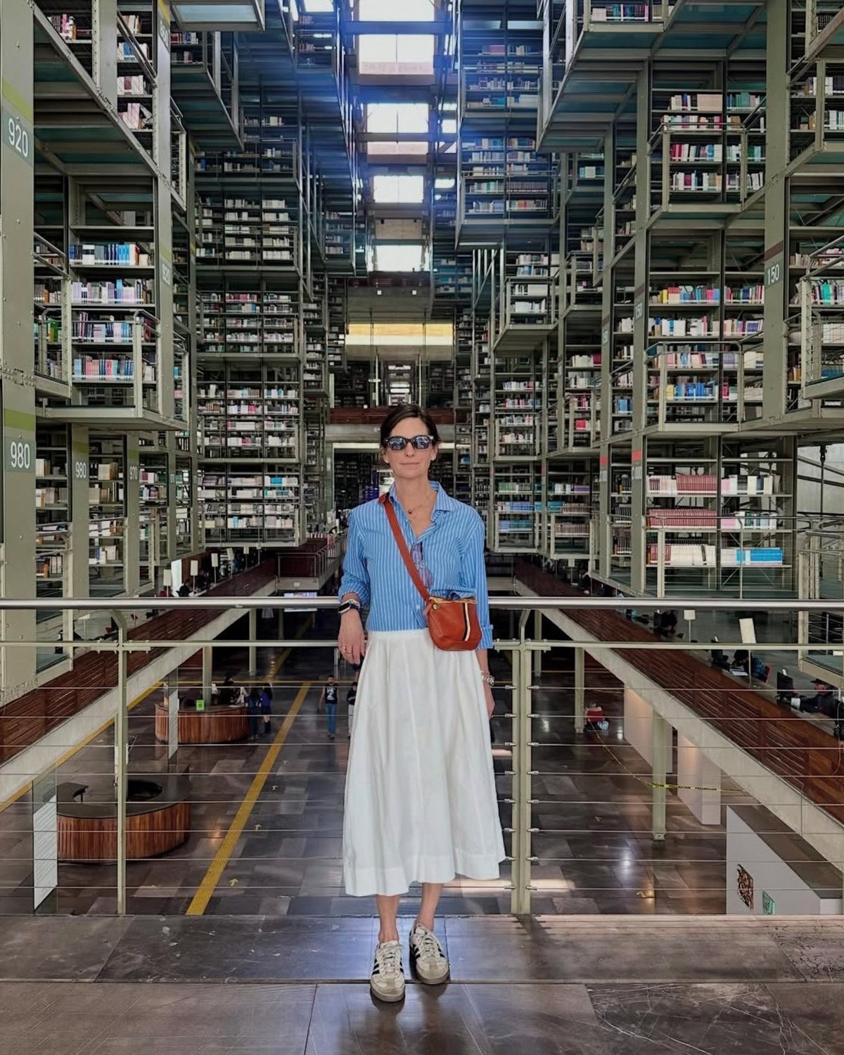 Woman posing in a beautiful library with our Fanny Pack across of her body.