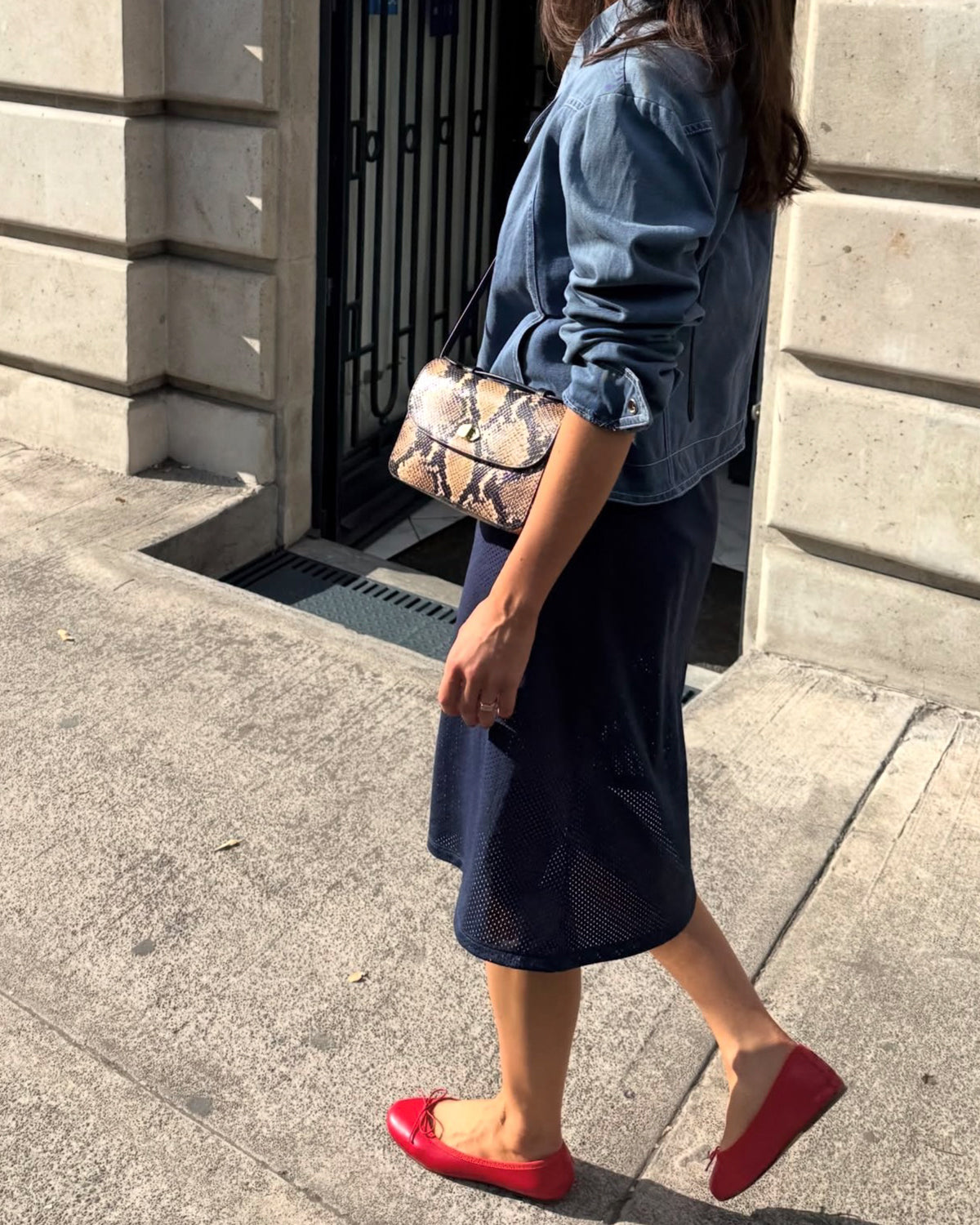 Woman carrying the Tan Desert Snake Kathryn. 