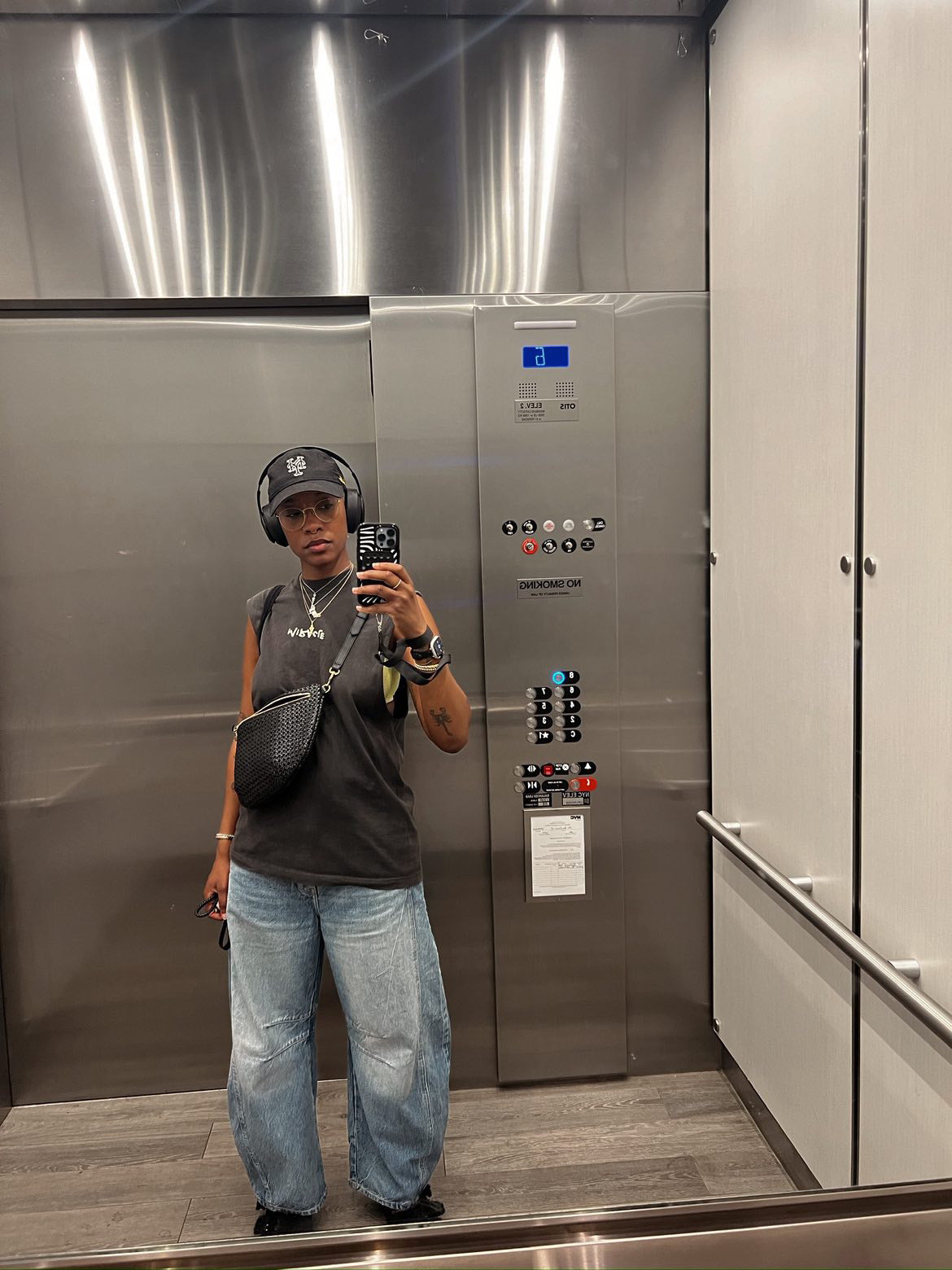 Woman taking a selfie in an elevator while carrying the Black Grande Fanny.