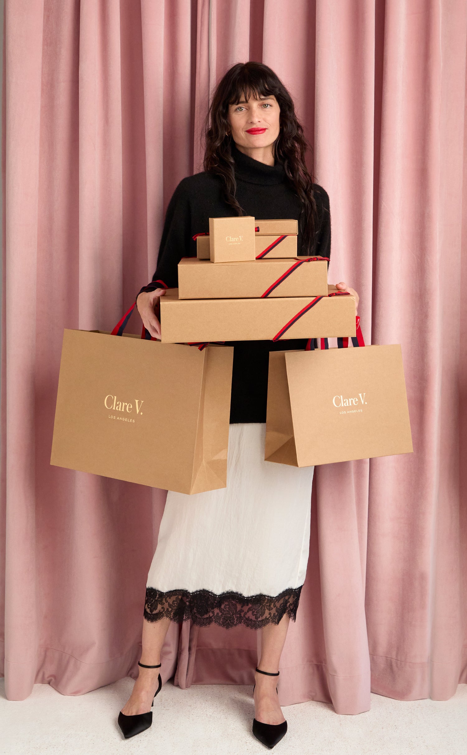 Model carrying Clare V. gift boxes.