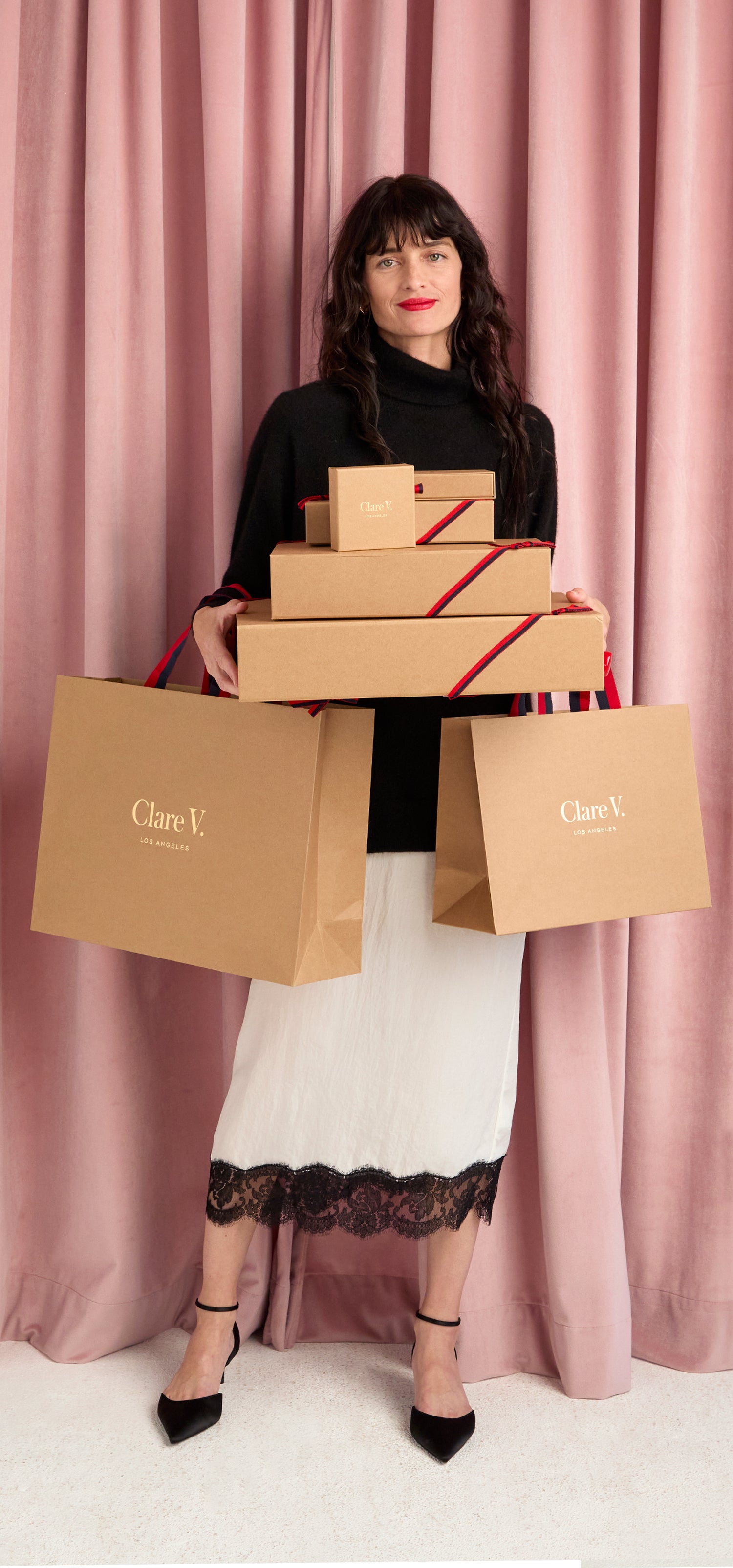 Model carrying Clare V. gift boxes.
