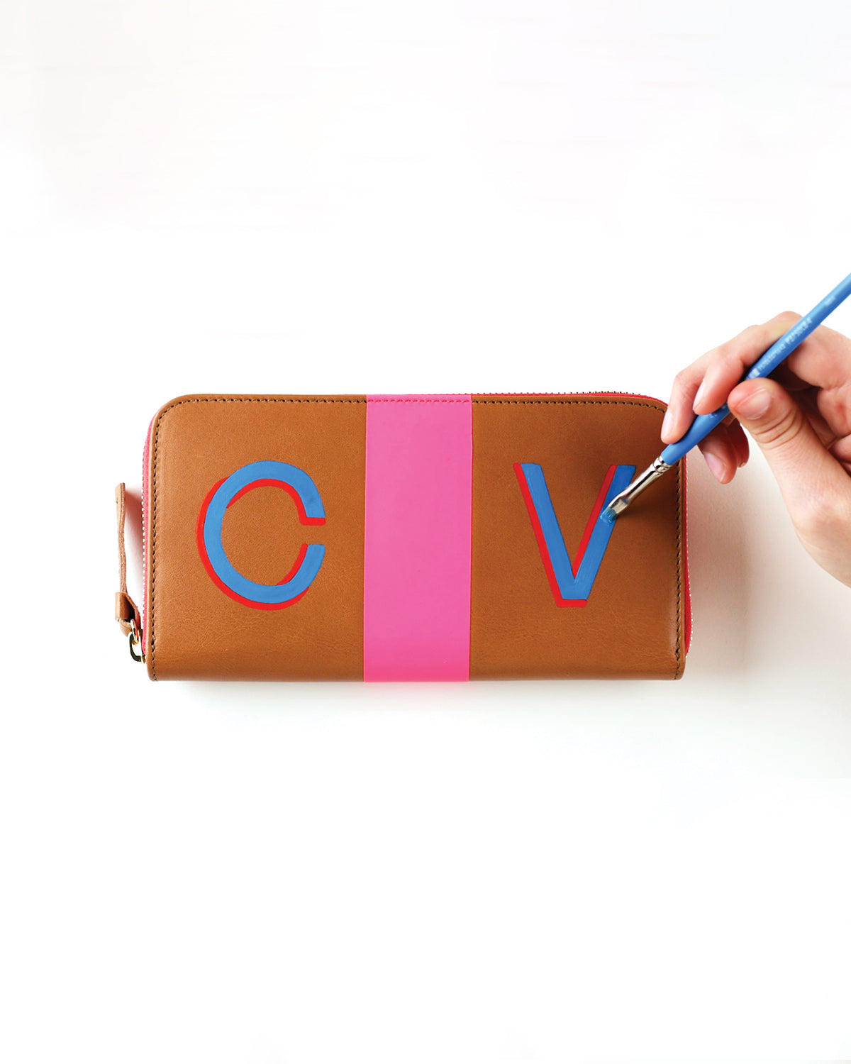 Zip Wallet with Neon PInk being handpainted with the letters C and V. 