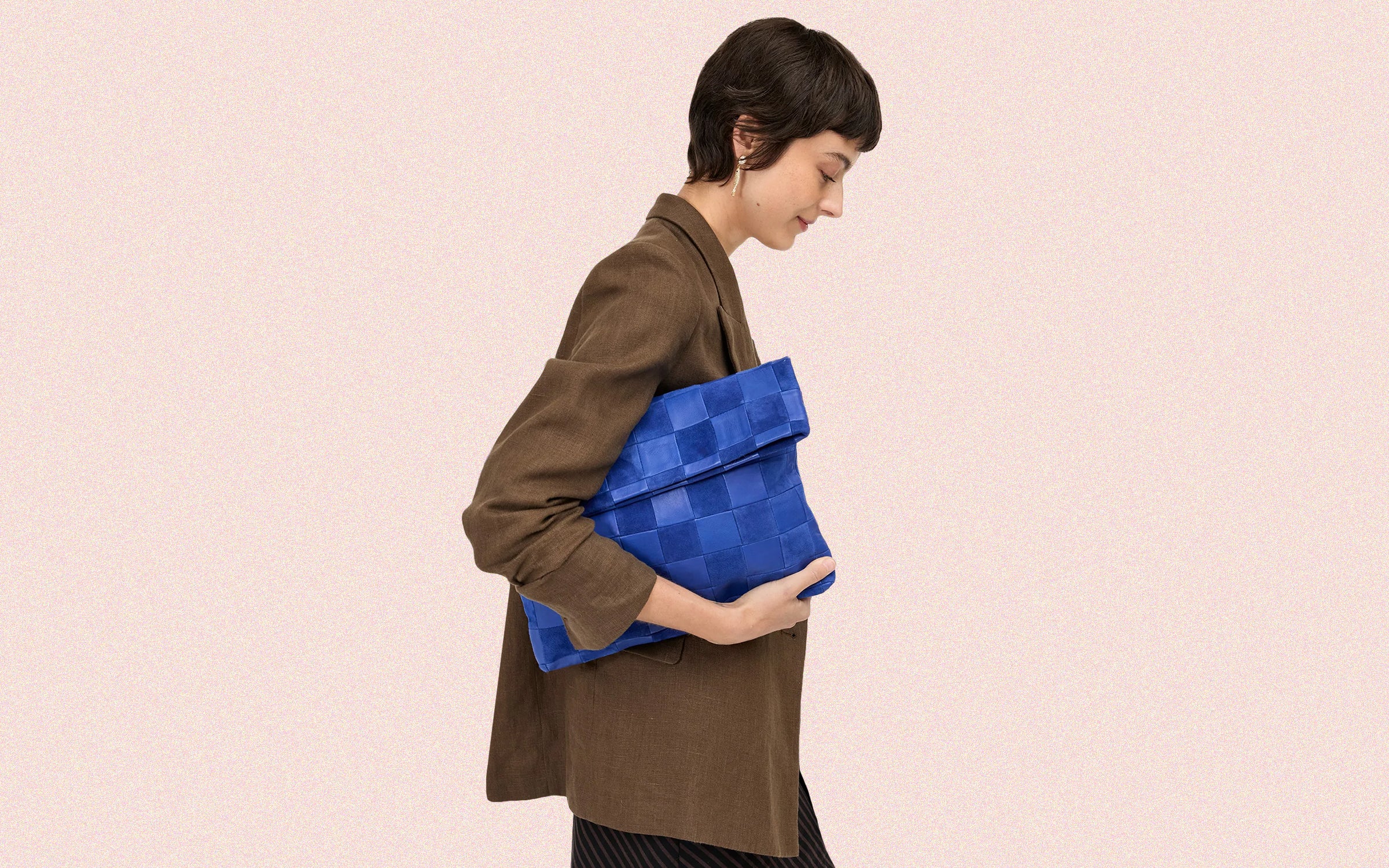Model carrying the Lagoon Caryall Clutch with Tabs.