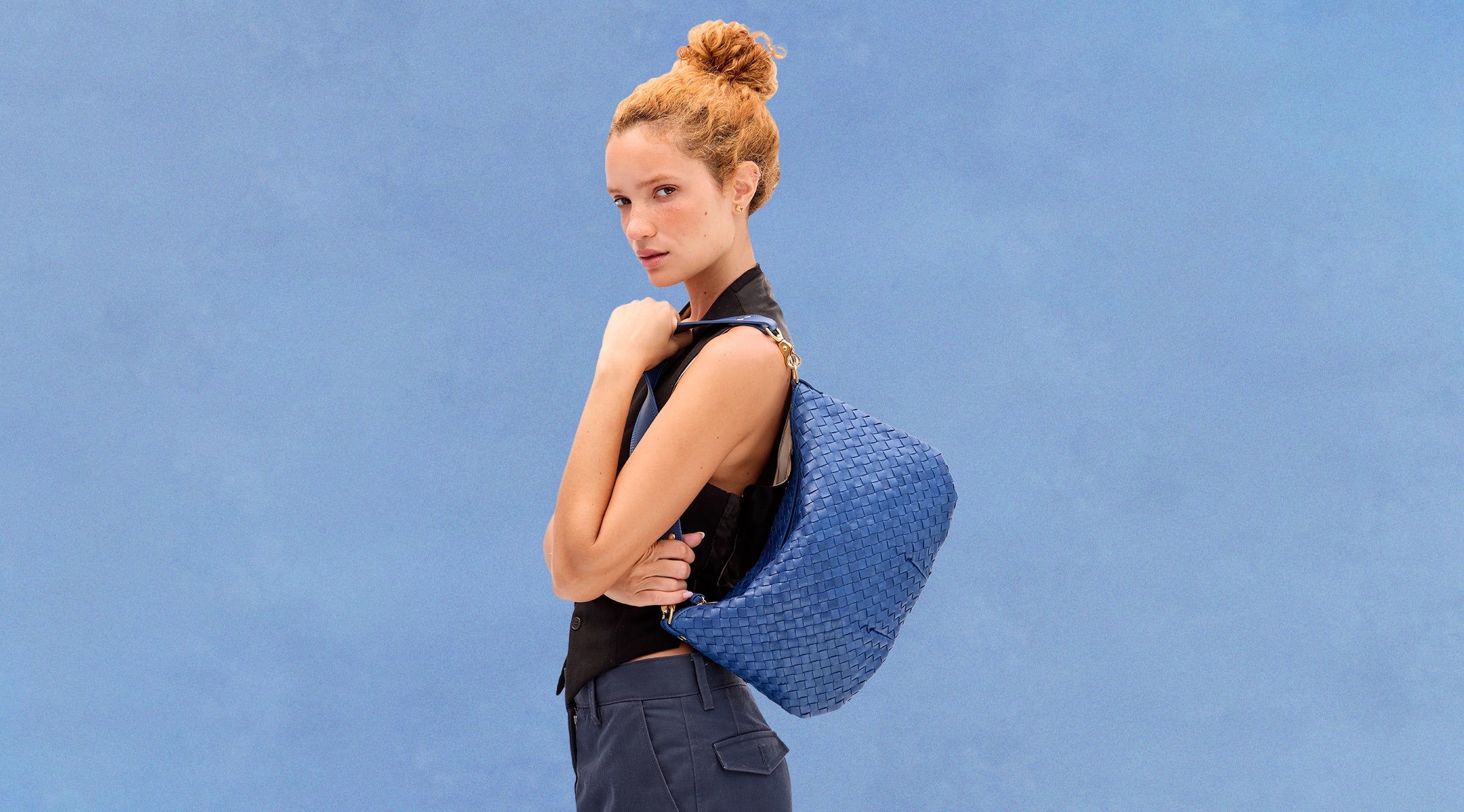Model carrying the French Blue Diagonal  Woven Moyen Messenger over her shoulder.