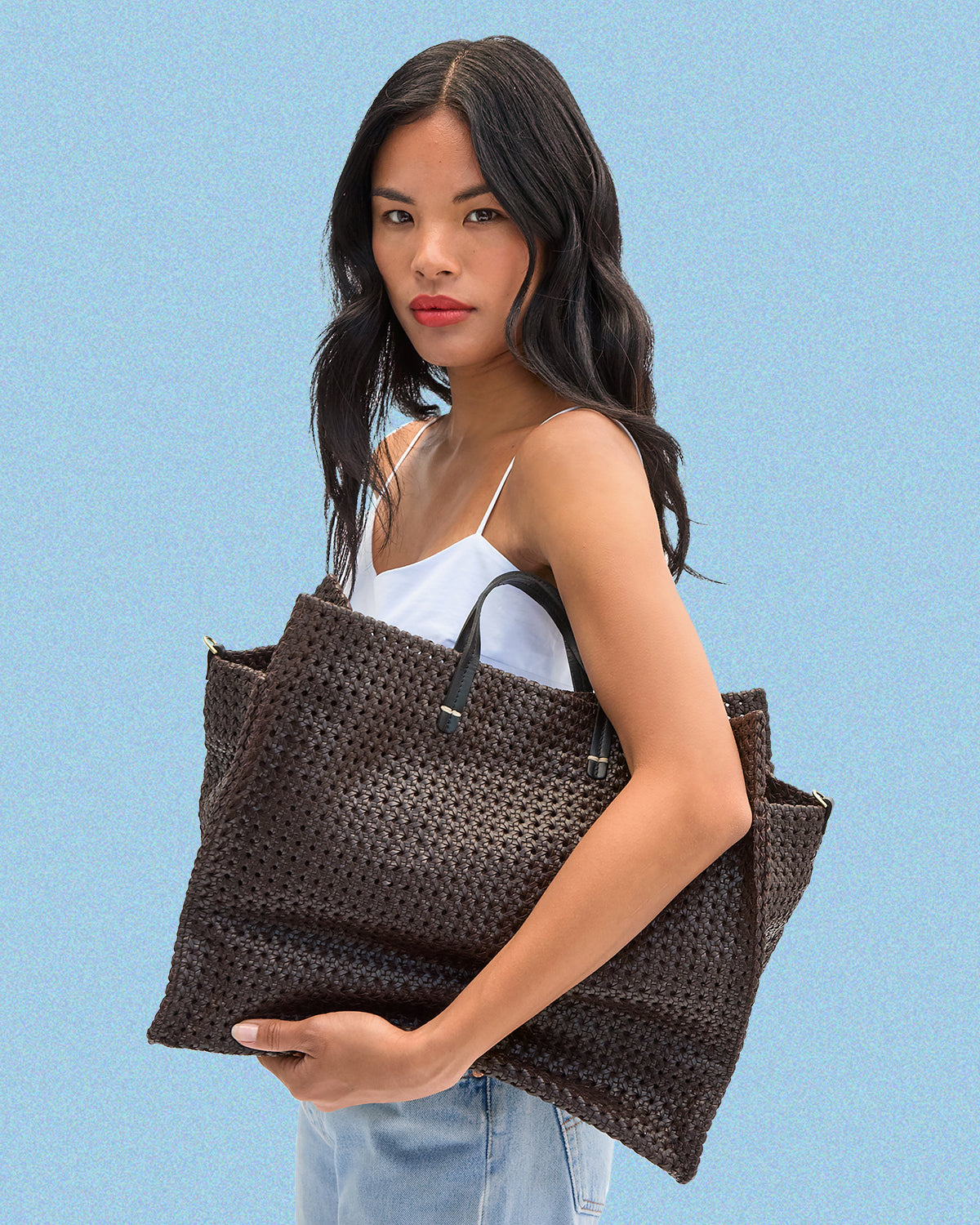 Model holding the Chocolate Rattan Simple Tote. 