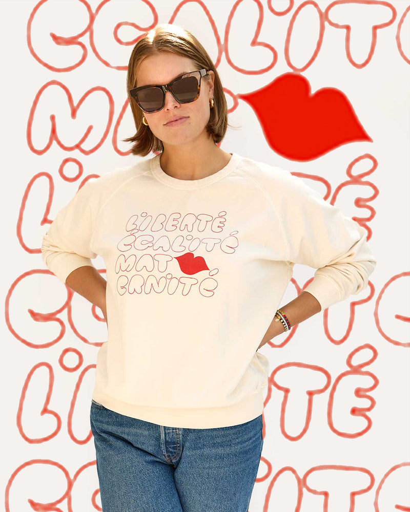 Sonnie wearing the Cream w/ Liberté Ègalité Maternité Sweatshirt with jeans.